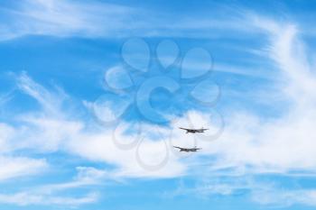 two strategic bomber aircrafts in white clouds in blue sky