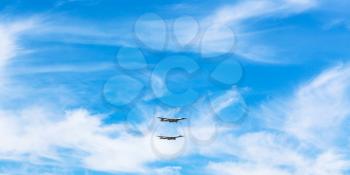 two strategic bomber airplanes in white clouds in blue sky
