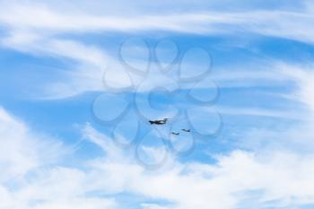 air refueling of military fighter airplanes in white clouds in blue sky