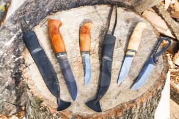hand made bowie knives on wooden stump