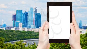 travel concept - tourist photograph cityscape with new Moscow City buildings in spring on tablet pc with cut out screen with blank place for advertising logo
