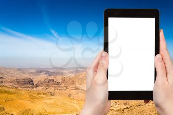 travel concept - tourist photograph mountain panorama of Jordan near Petra on tablet pc with cut out screen with blank place for advertising logo