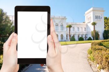 travel concept - tourist photograph facade of Grand Livadia Palace in Crimea. on tablet pc with cut out screen with blank place for advertising logo
