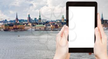 travel concept - tourist photograph panorama of Stockholm city in autumn day, Sweden on tablet pc with cut out screen with blank place for advertising logo