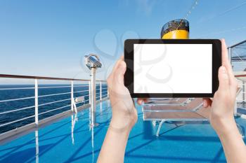 travel concept - tourist photograph sunbath chairs on upper deck of cruise liner on tablet pc with cut out screen with blank place for advertising logo