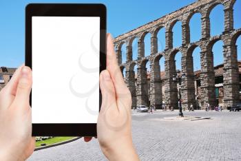 travel concept - tourist photograph Aqueduct of Segovia on Plaza del Azoguejo, Spain on tablet pc with cut out screen with blank place for advertising logo
