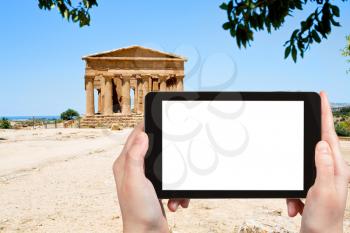 travel concept - tourist photograph ancient Temple of Concordia in Valley of the Temples, Agrigento, Sicily on tablet pc with cut out screen with blank place for advertising logo