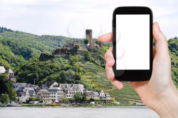 travel concept - tourist photograph Beilstein village and Metternich Castle, Germany on smartphone with cut out screen with blank place for advertising logo