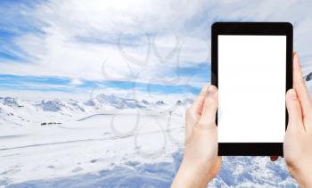 travel concept - tourist photograph mountain skiing on Alps in Paradiski region, Val d Isere - Tignes , France on tablet pc with cut out screen with blank place for advertising logo