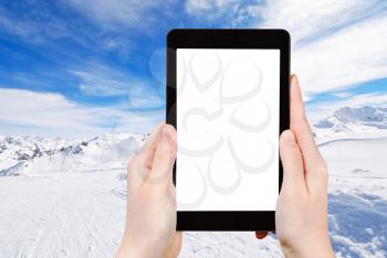 travel concept - tourist photograph snow skiing landscape of mountains in Paradiski region, Val d Isere - Tignes , France on tablet pc with cut out screen with blank place for advertising logo