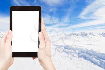 travel concept - tourist photograph skiing on snow slopes of mountains in Paradiski region, Val d Isere - Tignes, France on tablet pc with cut out screen with blank place for advertising logo