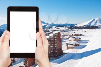 travel concept - tourist photograph above view of Avoriaz town in Alps, Portes du Soleil region, France on tablet pc with cut out screen with blank place for advertising logo