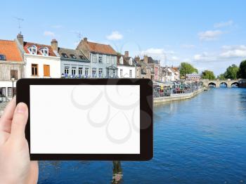 travel concept - tourist photograph Quai Belu on Somme river in Amiens city, France on tablet pc with cut out screen with blank place for advertising logo