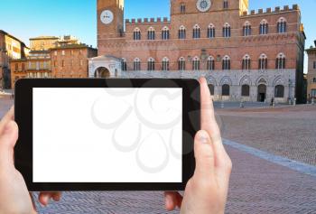travel concept - tourist photograph Piazza del Campo in Siena, Italy on tablet pc with cut out screen with blank place for advertising logo