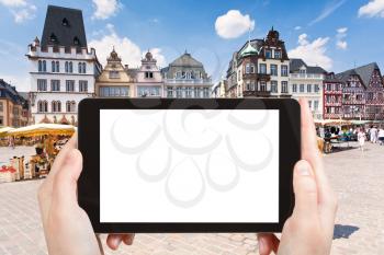 travel concept - tourist photograph old Market square in Trier, Germany on tablet pc with cut out screen with blank place for advertising logo