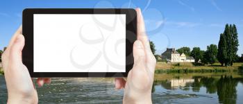 travel concept - tourist photograph town Amboise on riverbank of Loire river, France on tablet pc with cut out screen with blank place for advertising logo
