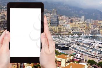 travel concept - tourist photograph panorama of Monaco city with marine on tablet pc with cut out screen with blank place for advertising logo