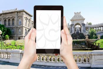 travel concept - tourist photograph fountain in Palais de Longchamp, Marseilles, France on tablet pc with cut out screen with blank place for advertising logo
