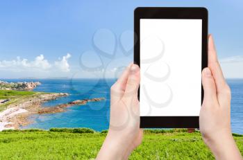 travel concept - tourist photograph panorama of Cote D Emeraude in Normandy, France on tablet pc with cut out screen with blank place for advertising logo