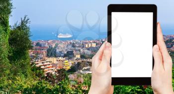 travel concept - tourist photograph Cannes city and Azure Coast, France on tablet pc with cut out screen with blank place for advertising logo