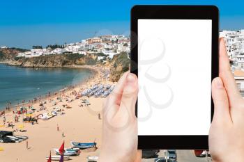 travel concept - tourist photograph town beach of Bryn at Albufeira, Portugal on tablet pc with cut out screen with blank place for advertising logo