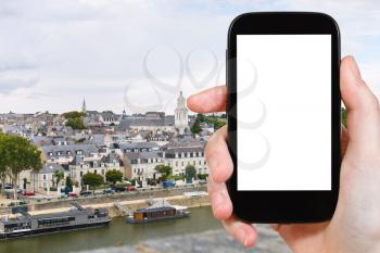 travel concept - tourist photograph quay des Carmes in Anges, France on smartphone with cut out screen with blank place for advertising logo
