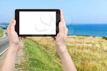 travel concept - tourist photograph coastline of Sea of Azov in resort village Golubitskaya on Taman Peninsula, Russia on tablet pc with cut out screen with blank place for advertising logo