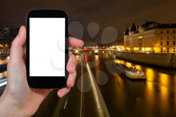 travel concept - tourist photograph panorama of Seine with Pont au Change in Paris, France at night on smartphone with cut out screen with blank place for advertising logo