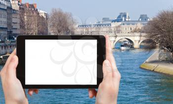 travel concept - tourist photograph Pont Neuf in Paris, France in spring morning on tablet pc with cut out screen with blank place for advertising logo