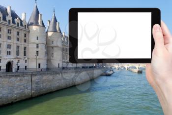 travel concept - tourist photograph Conciergerie palace and Pont Neuf in Paris on Quai de l Horloge, France on tablet pc with cut out screen with blank place for advertising logo