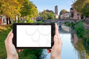travel concept - tourist photograph bridge on Brenta River in Padua city, Italy on tablet pc with cut out screen with blank place for advertising logo