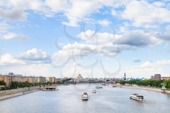 MOSCOW, RUSSIA - MAY 30, 2015: excursion ships in Moskva River near Krymsky Bridge in center of Moscow with Cathedral of Christ the Saviour and Peter The Great Monument, Russia