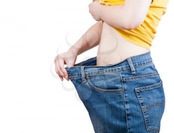 emaciated girl trying on large size old jeans isolated on white background