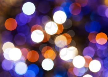 abstract blurred background - blue, red and violet shimmering Christmas lights of electric garlands on Xmas tree