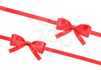 two big red satin bows and two diagonal ribbons isolated on horizontal white background