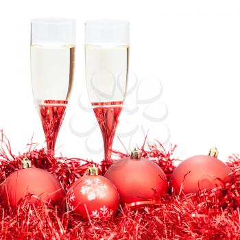 two glasses of champagne at red Christmas decorations isolated on white background