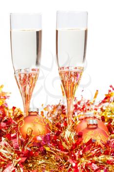 two glasses of champagne at yellow and golden Christmas decorations isolated on white background