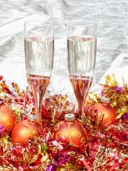 Christmas still life - Two glasses of champagne with orange Xmas decorations on gold background