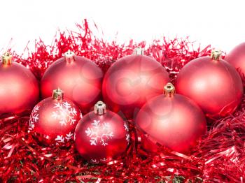 many red Christmas baubles and tinsel isolated on white background
