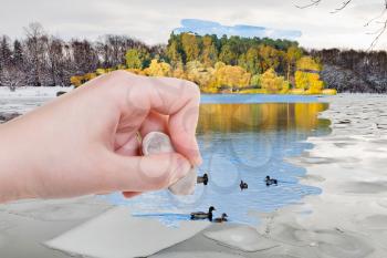 weather concept - hand deletes ice blocks in winter river by rubber eraser from image and autumn natural landscape are appearing