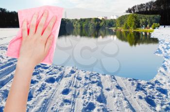 season concept - hand deletes snow field on frozen river by pink cloth from image and summer riverbank is appearing