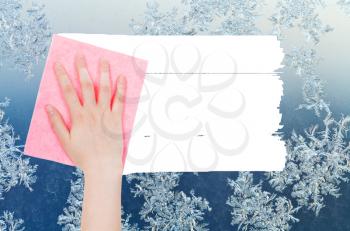 weather concept - hand deletes winter snoflakes on window by pink rag from image and white empty copy space are appearing