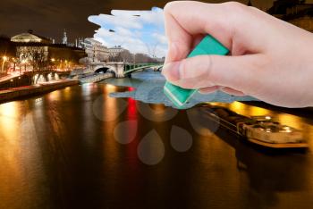 travel concept - hand deletes night scenery of Paris city by rubber eraser from image and day cityscape are appearing