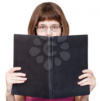 direct view of girl with glasses looks over big book with blank cover isolated on white background
