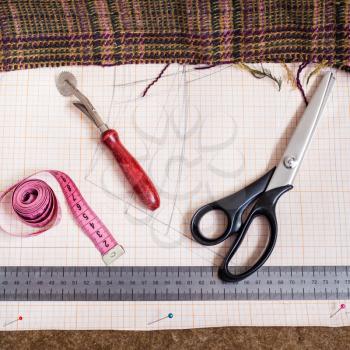 dressmaking still life - top view of cutting table with fabric, pattern, tailoring tools
