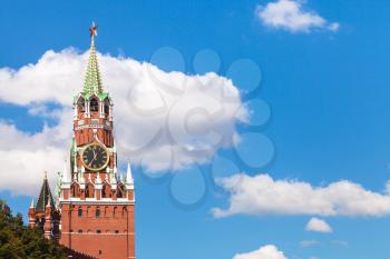 Spasskaya clock Tower of Moscow Kremlin and white clouds in blue sky in sunny summer day