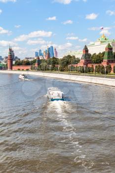 Moscow cityscape - boat in Moskva River, Kremlin, Moscow City district in sunny summer day