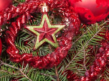 Christmas still life - red star, Christmas baubles, tinsel on Xmas tree background