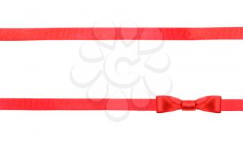 one red satin bow knot in lower right corner and two horizontal ribbons isolated on horizontal white background