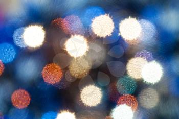 abstract blurred background - blue shimmering Christmas lights bokeh from soft filter of electric garlands on Xmas tree